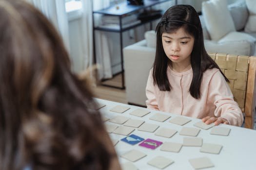 Young girl with Down syndrome focuses on a memory game at a home table.